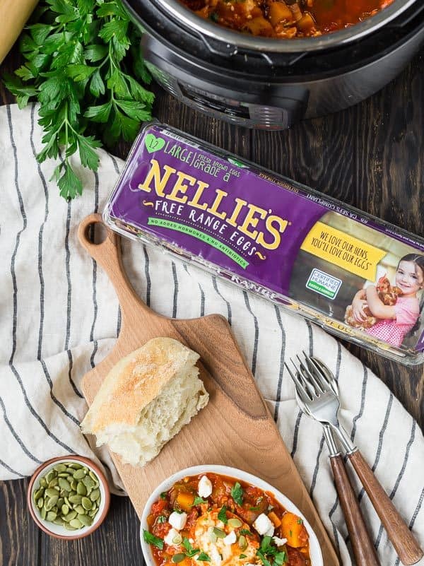 Overhead view of a carton of Nellie's Free Range eggs with bread, pepitas, and shakshuka.