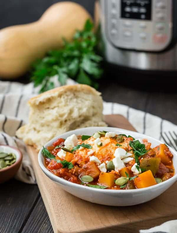 Small bowl of tomatoes, eggs, feta cheese, and pepitas. An instant pot is pictured in the background.