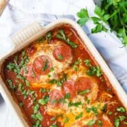 image of chicken topped with cheese and pepperoni in a baking dish