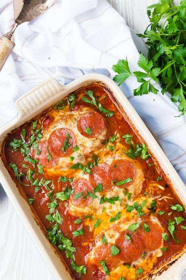 image of pizza chicken topped with cheese and pepperoni in a baking dish