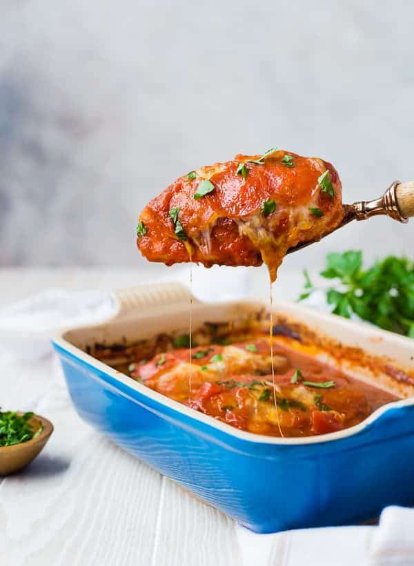 Front view of chicken in baking dish with portion being scooped out.