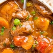 Close up overhead view of a spoonful of Instant Pot beef stew lifted from a bowlful.