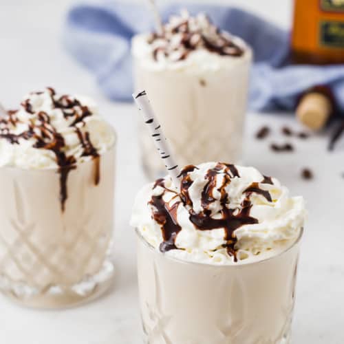 Image of three whiskey milkshakes topped with whipped cream and chocolate sauce.