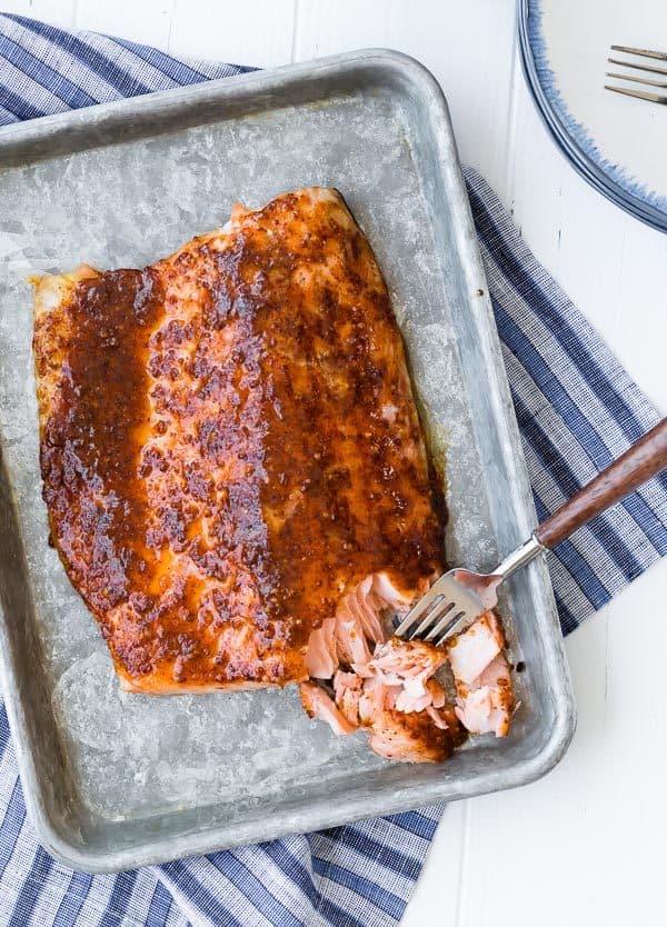 This easy five ingredient baked salmon is going to be your weeknight go-to salmon recipe. The glaze is the perfect balance of spicy and sweet. Try it tonight!