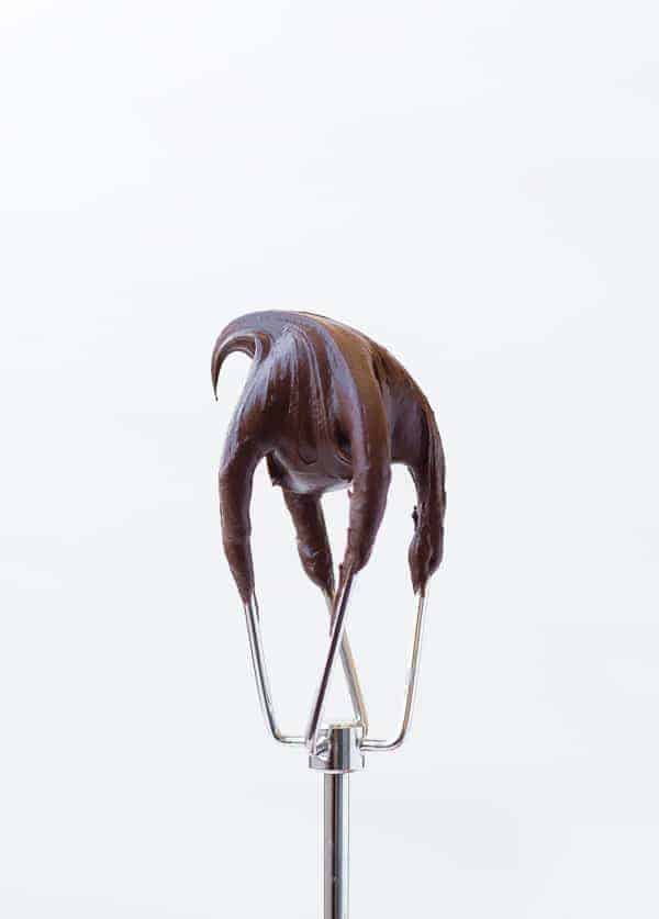 Image of Chocolate Cream Cheese Frosting on a electric beater attachment on a white background