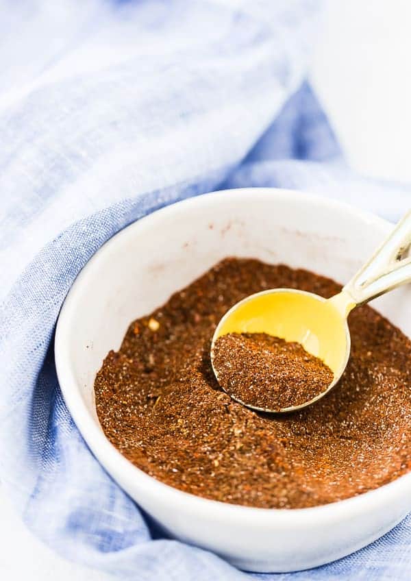 Spices in a white bowl with a blue towel in the background. 