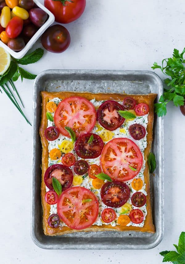 This fresh tomato tart with herbed ricotta tastes like summer on a flaky puff pastry crust. It's easy to make and visually stunning. Make it for your next party! 