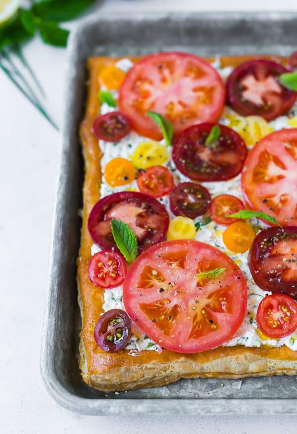 This fresh tomato tart with herbed ricotta tastes like summer on a flaky puff pastry crust. It's easy to make and visually stunning. Make it for your next party! 