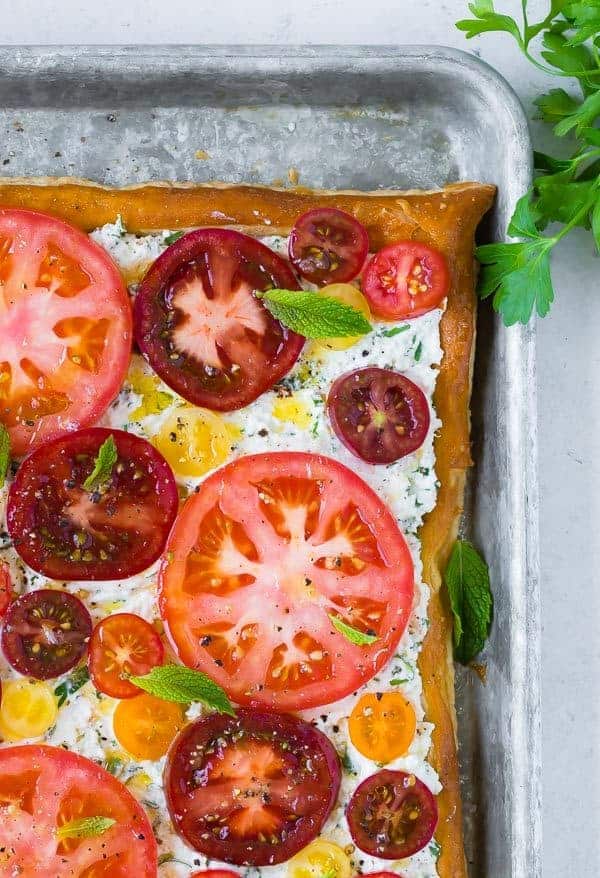 Image of herbed ricotta and fresh tomato tart, taken from above. Garnished with mint leaves. 