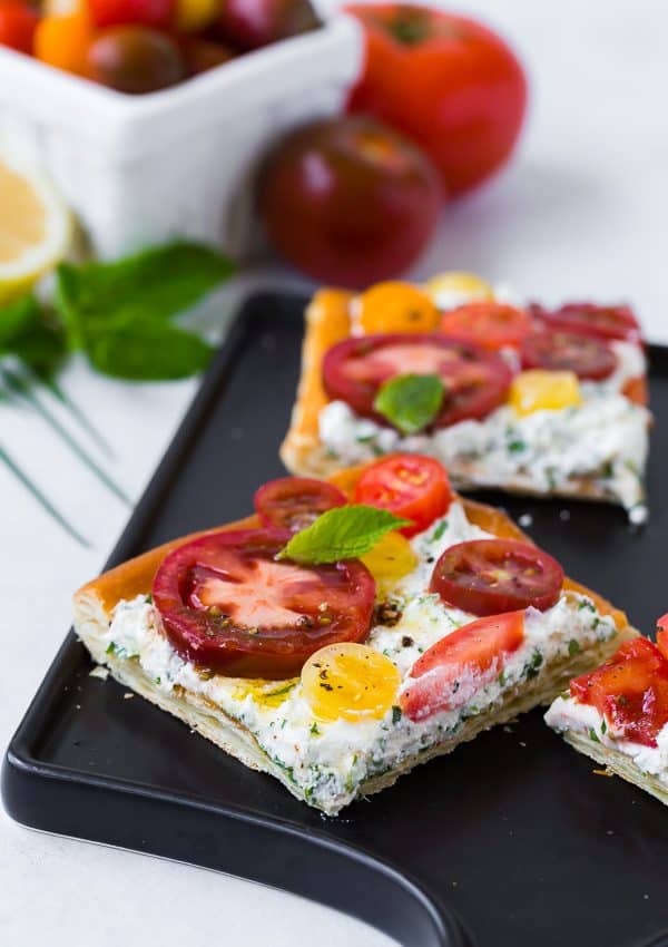 This fresh tomato tart with herbed ricotta tastes like summer on a flaky puff pastry crust. It's easy to make and visually stunning. Make it for your next party! 