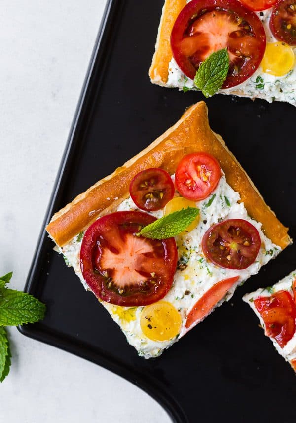 This fresh tomato tart with herbed ricotta tastes like summer on a flaky puff pastry crust. It's easy to make and visually stunning. Make it for your next party! 