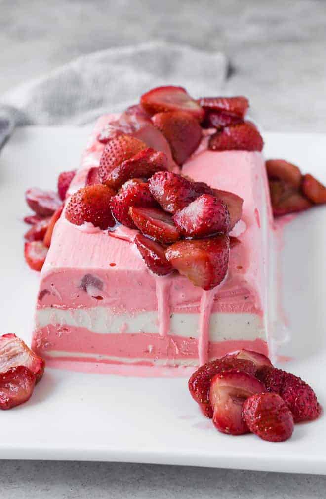 Close up of entire ice cream terrine on plate with roasted strawberries