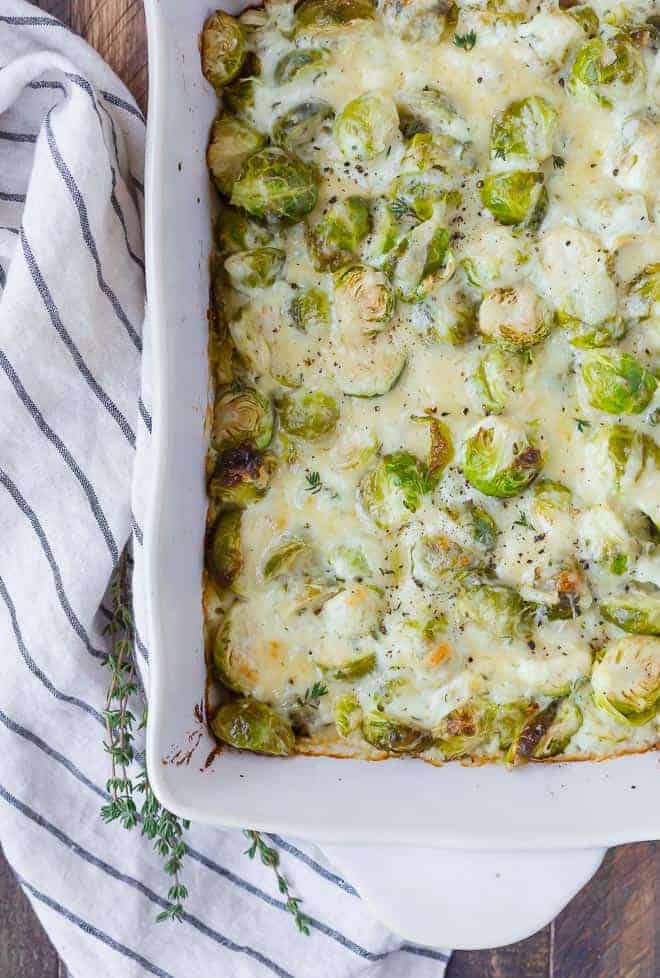 Brussels gratin in a white baking dish. Fresh thyme also pictured.