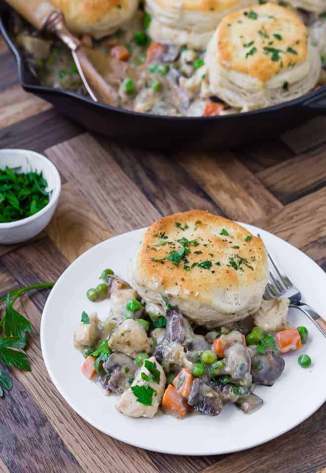 Image of one pan chicken pot pie recipe, made in a skillet, scooped onto a white plate.
