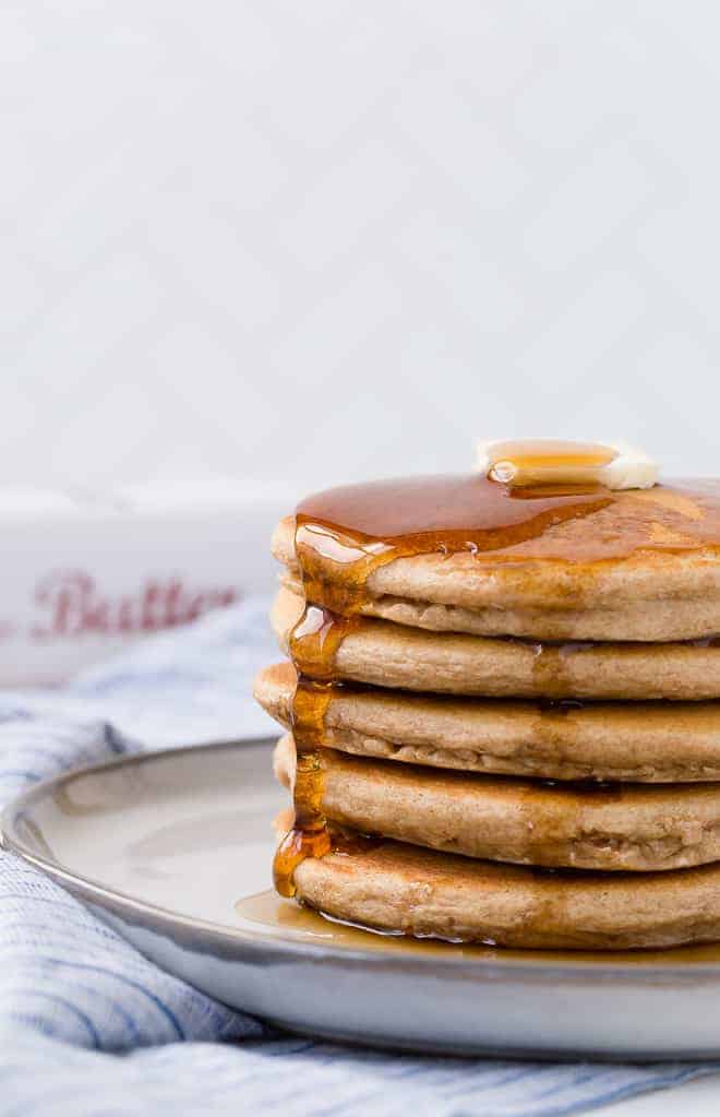 image of a beautiful stack of whole wheat pancakes with butter and maple syrup.