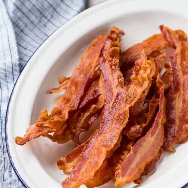 Image of baked bacon on a white platter.
