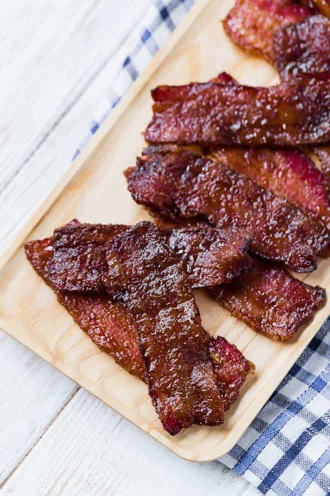 Image of candied bacon on a wooden serving plate.