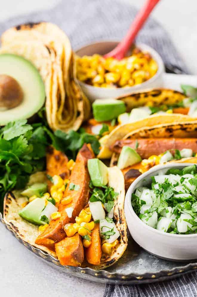 Beer marinated roasted sweet potatoes, charred corn, creamy avocado, crisp onions, and fresh cilantro, wrapped in a soft corn tortilla, make these vegetarian sweet potato tacos a taste sensation! 