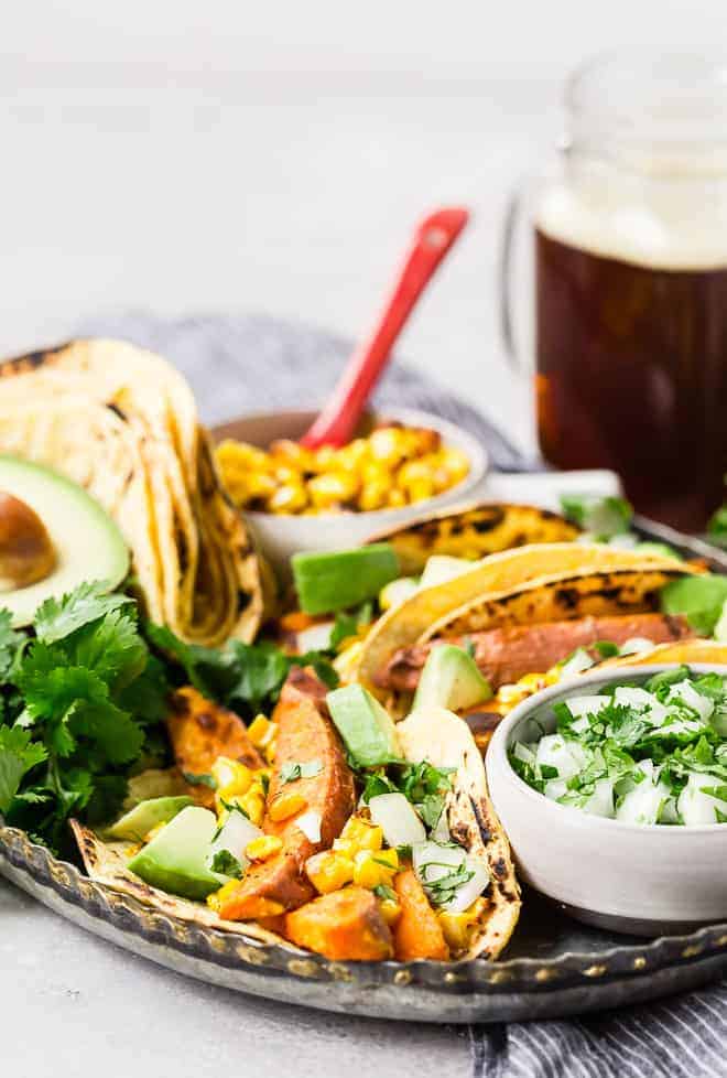 Beer marinated roasted sweet potatoes, charred corn, creamy avocado, crisp onions, and fresh cilantro, wrapped in a soft corn tortilla, make these vegetarian sweet potato tacos a taste sensation! 