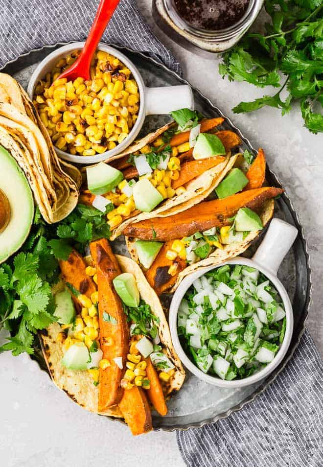 Beer marinated roasted sweet potatoes, charred corn, creamy avocado, crisp onions, and fresh cilantro, wrapped in a soft corn tortilla, make these vegetarian sweet potato tacos a taste sensation! 