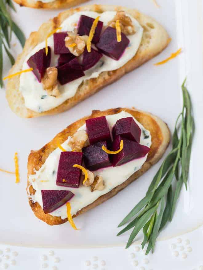 Beautiful beets and goat cheese on top of bruschetta, garnished with walnuts and orange zest.