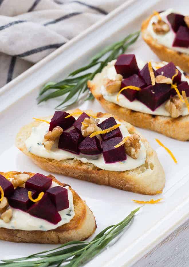 Close up of beet crostini on a white platter.