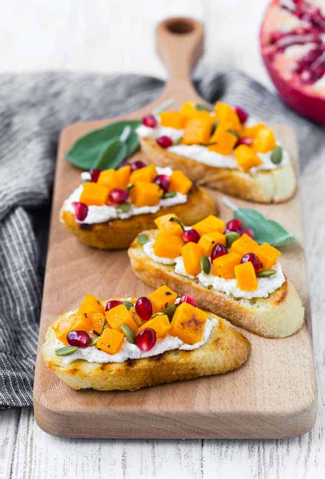 Crostini with squash, pomegranate, ricotta, and pepitas.