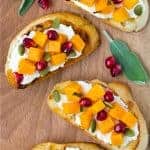 Image of butternut squash crostini topped with pomegranate and pepitas.