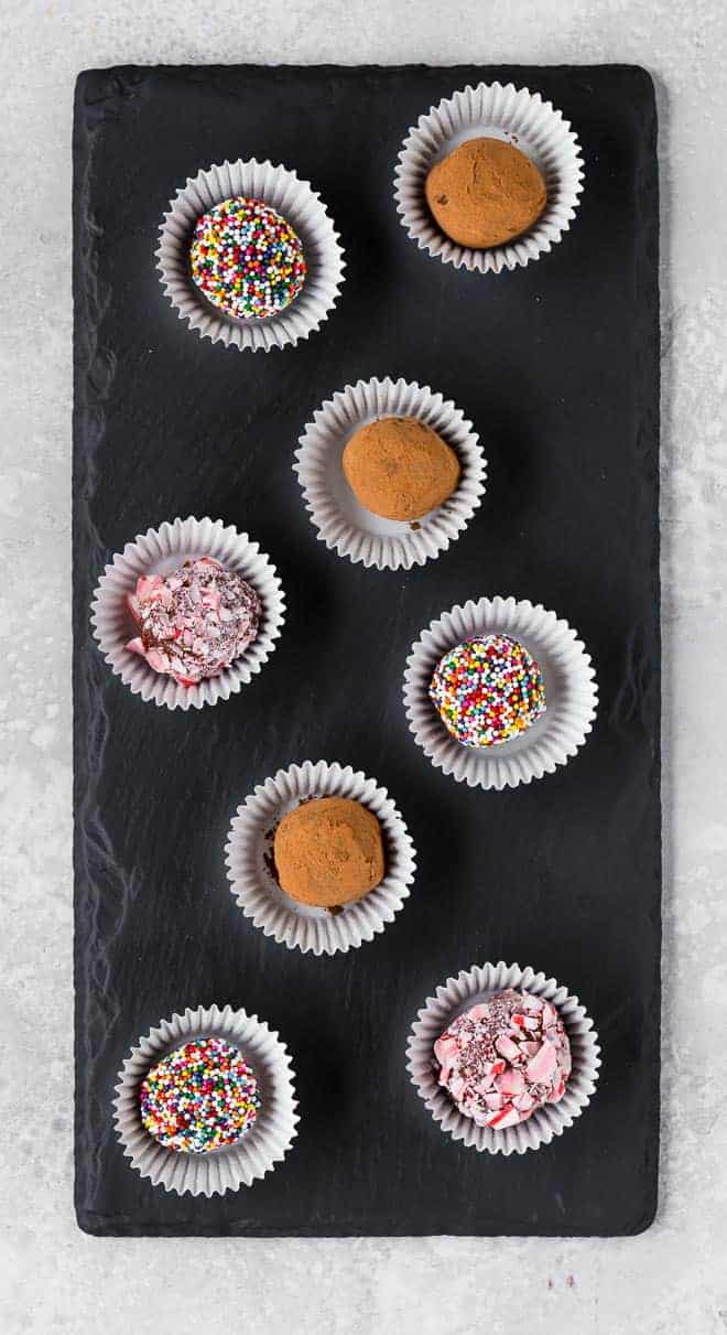 An arrangement of several fudge candies arranged on a black slate board.