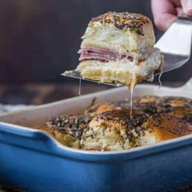 Image of ham and cheese sliders being taken out of a pan.