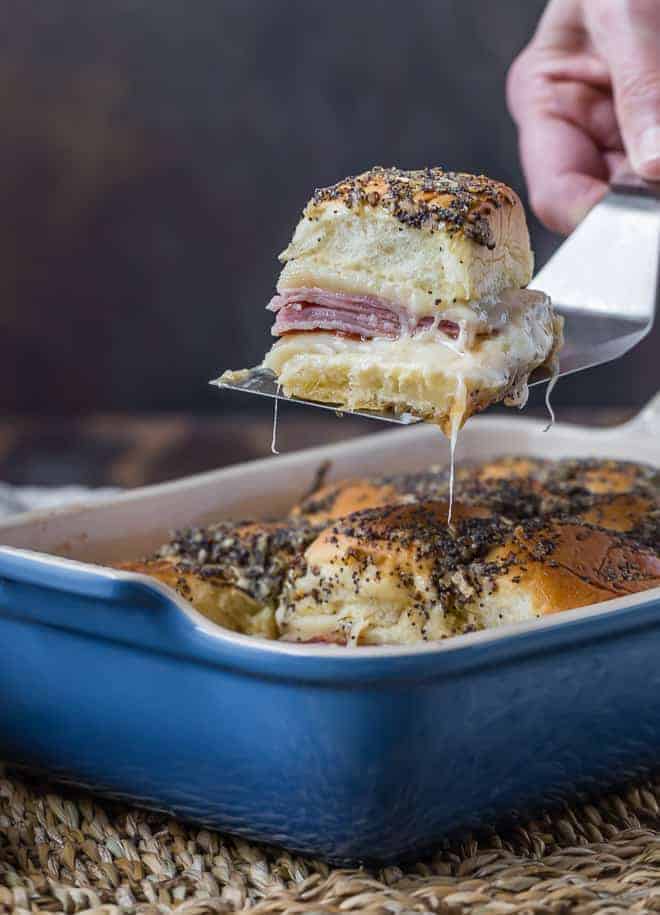 Image of ham and cheese sliders being taken out of a pan.