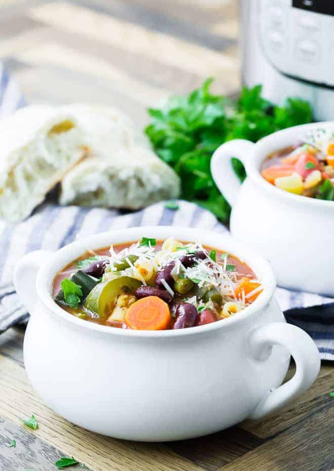 Image of minestrone soup in a white bowl.