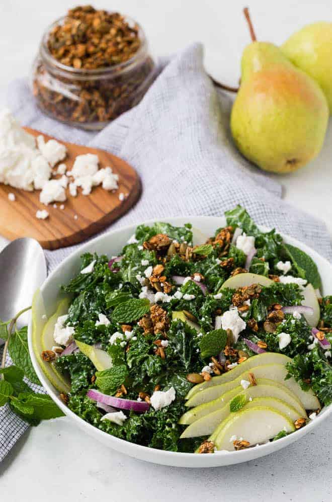 Kale salad topped with pear, feta, and savory granola.