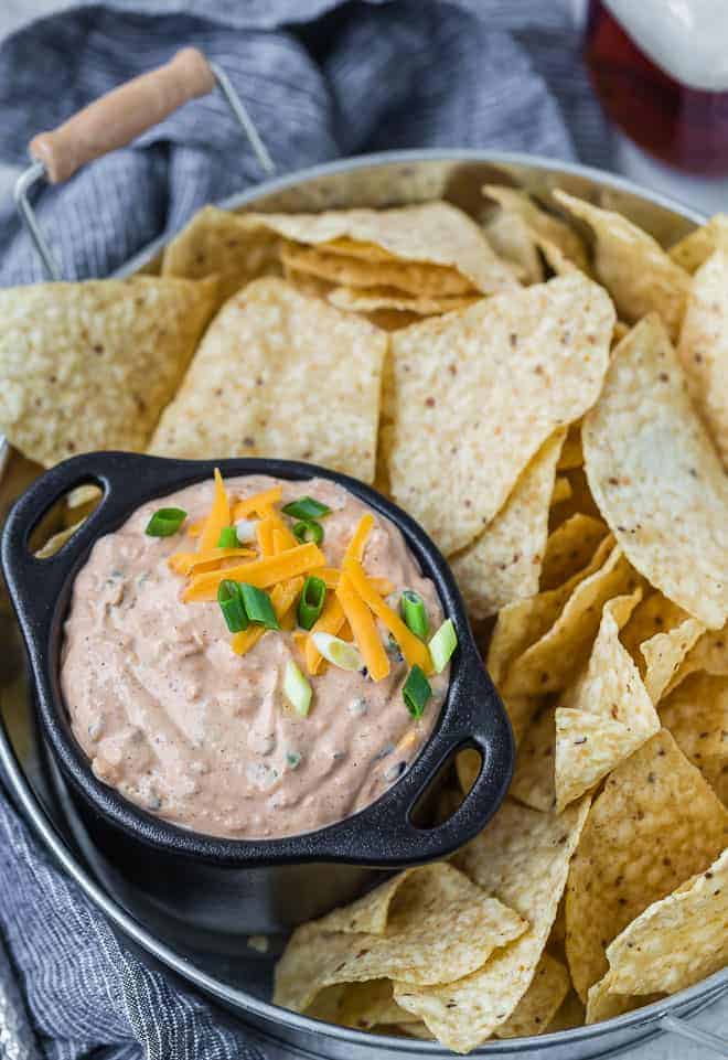 Image of mexican style creamy dip served on a tray with chips.