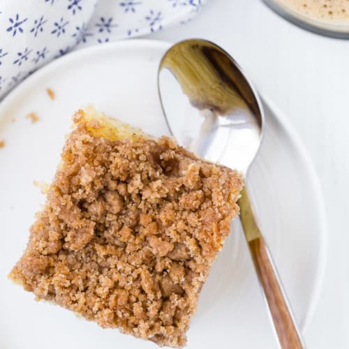 Image of a piece of coffee cake, captured from above, topped with lots of crunchy cinnamon streusel.
