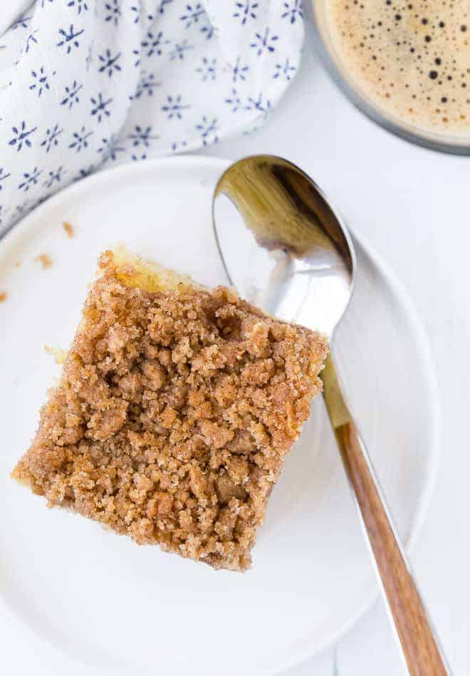 Image of a piece of coffee cake, captured from above, topped with lots of crunchy cinnamon streusel. 