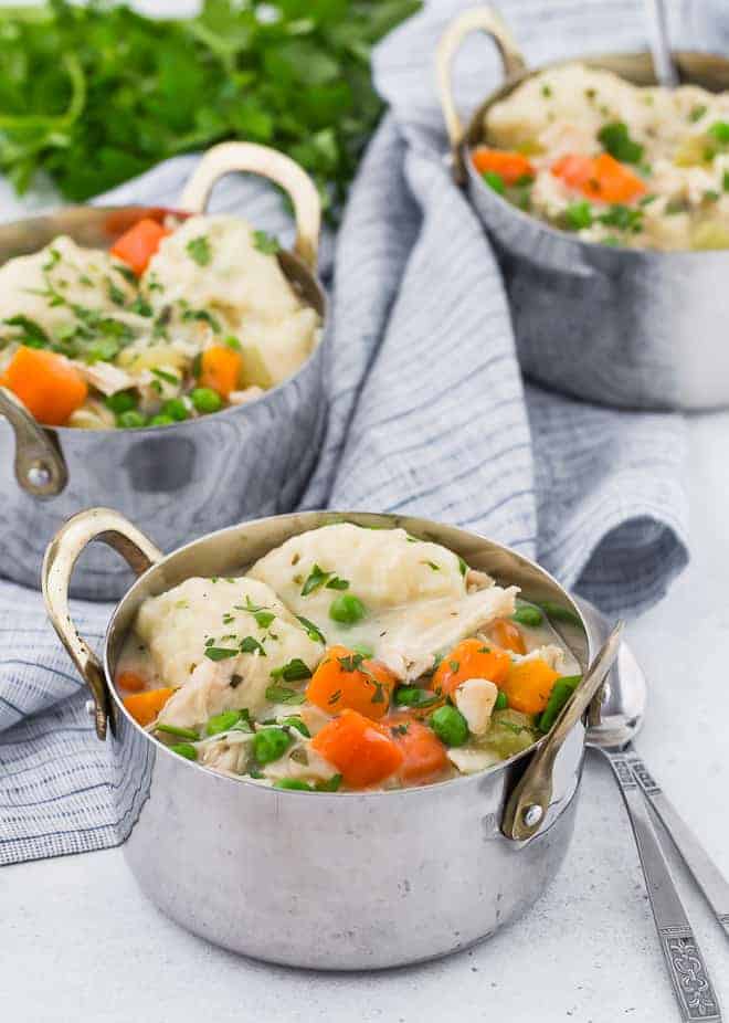 Image of three metal crocks of chicken and dumplings, garnished with fresh parsley.