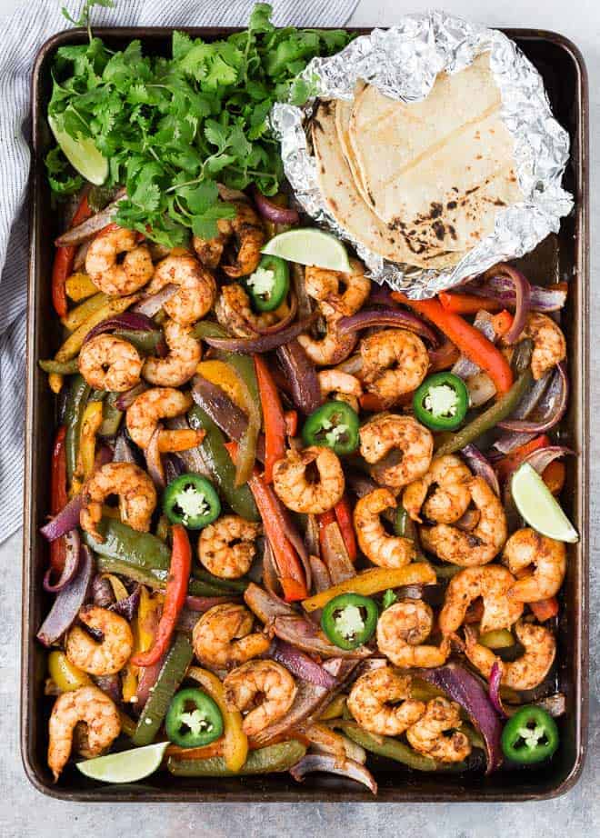 Sheet pan full of colorful vegetables and marinated shrimp. 