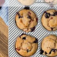 Overhead image of muffins in a tin with a text overlay that reads "strawberry blueberry muffins"