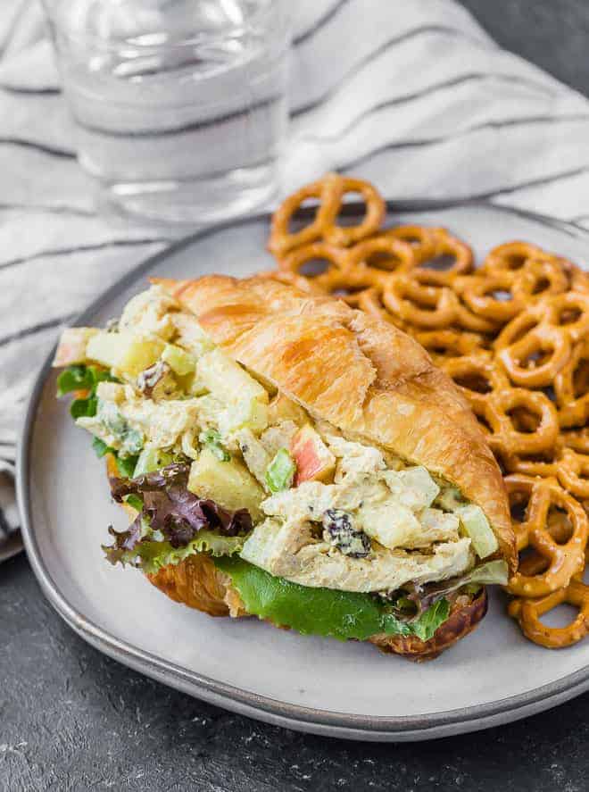 Image of healthy curried chicken salad on a croissant with fresh greens.