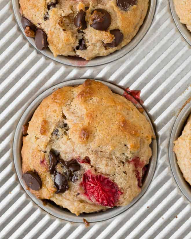 Overhead image of a strawberry muffin with chocolate chips in a baking tin.