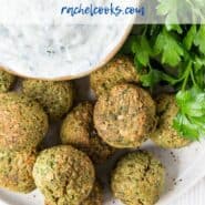 Overhead view of falafel, tzatziki, and fresh parsley, with a text overlay that reads "air fryer falafel, rachelcooks.com"