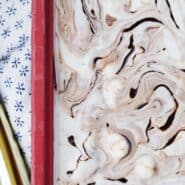 Fudge swirl ice cream in a red pan, with a scoop. Text overlay present with recipe name.