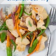 Overhead view of a white plate filled with white rice, chicken, sugar snap peas, carrots, and red onions in stir fry form. It is garnished with fresh basil ribbons.