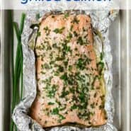 Overhead view of grilled salmon in a foil pack. Text overlay reads "garlic butter grilled salmon."