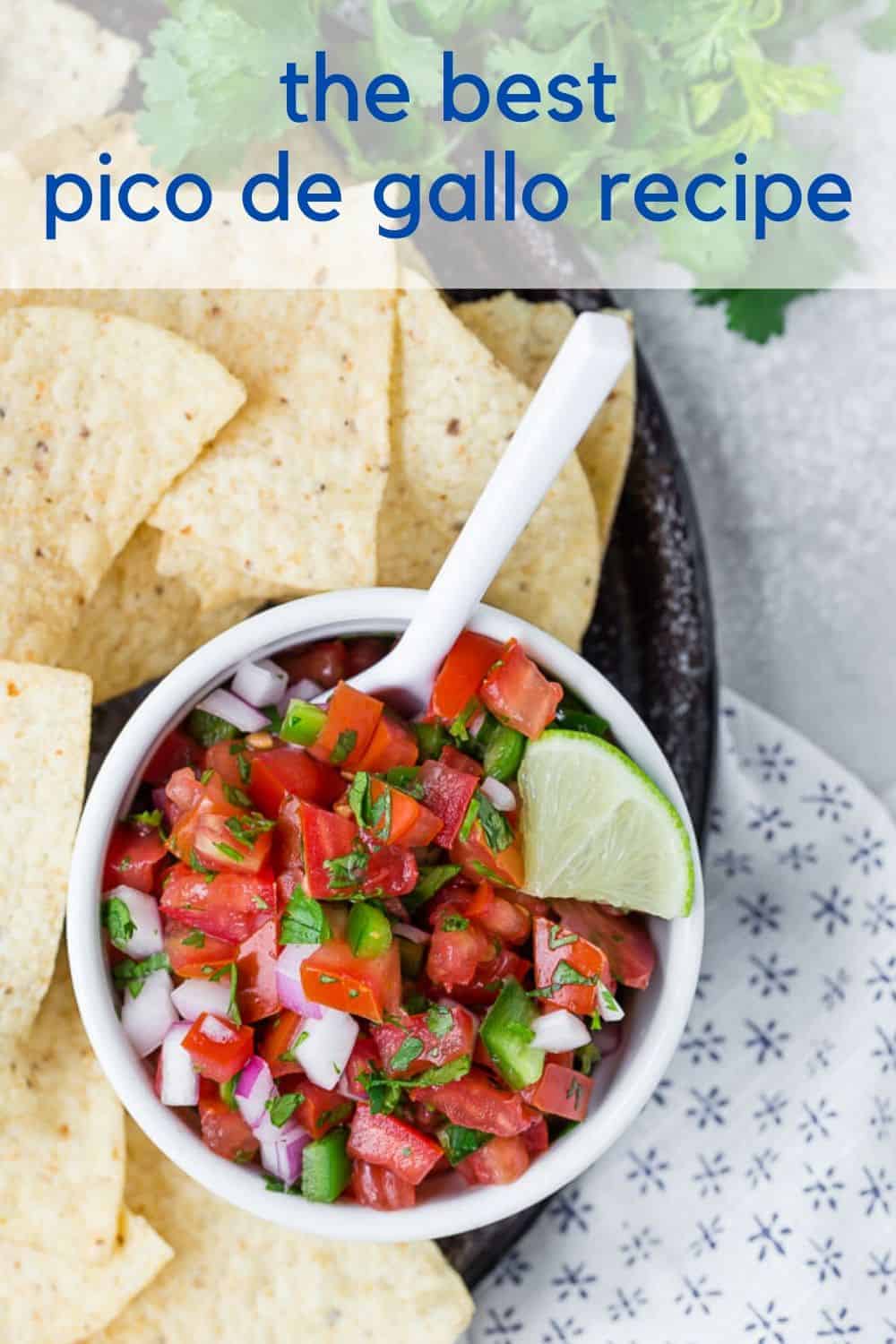 Overhead view of a white bowl of tomatoes, jalapenos, and onions with a text overlay that reads "the best pico de gallo"