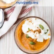 Overhead view of pumpkin pudding garnished with pumpkin seeds and whipped cream.