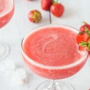 Frozen Rose wine in a stemmed glass garnished with strawberries.