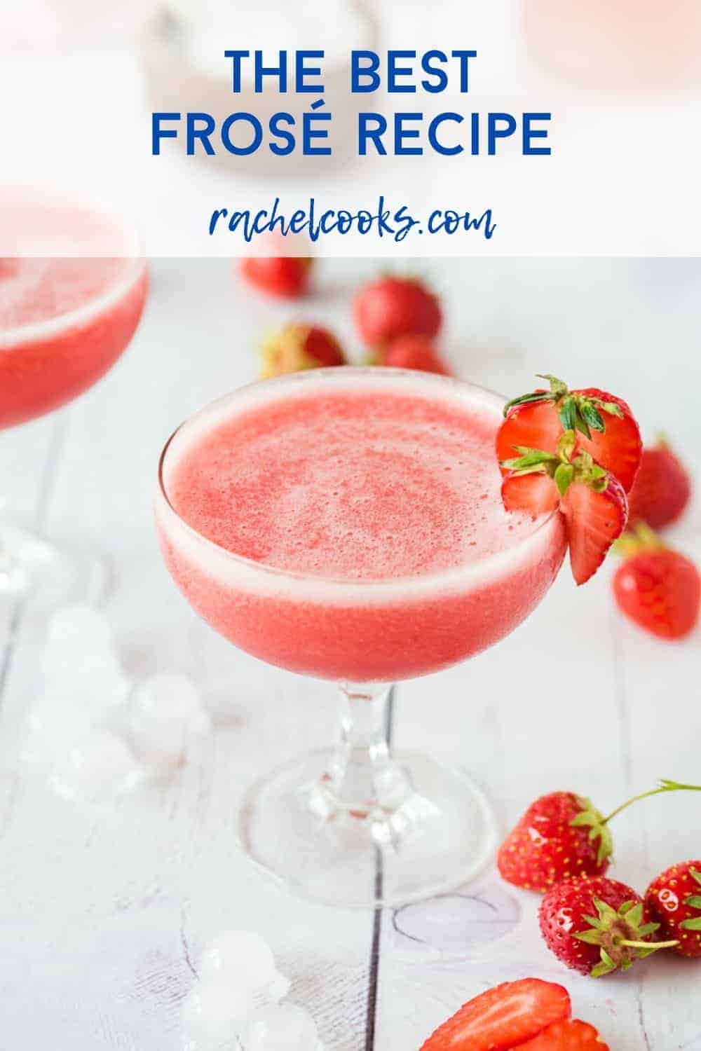 Frozen Rosé in a stemmed glass, garnished with strawberries, strawberries also scattered around.