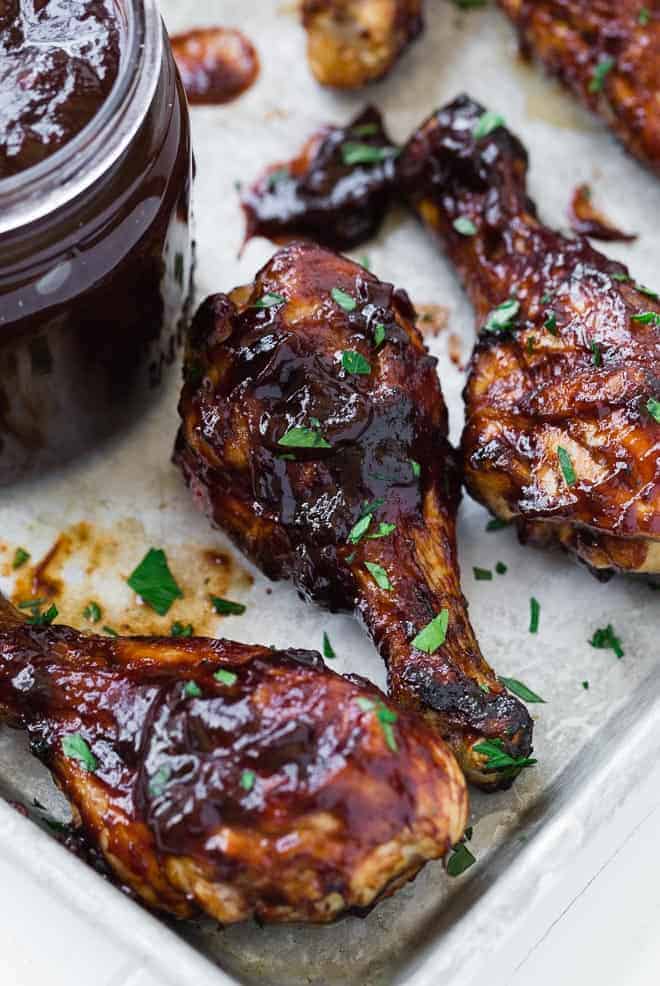 Close up image of a chicken drumstick with BBQ sauce.